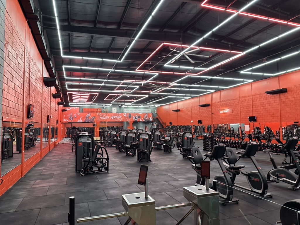 Selfit gym floor with rows of strength machines, cardio bikes and free weights